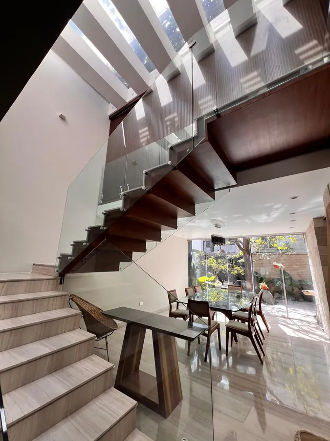 Interior con escalera y comedor de madera — casa residencial construida por Prisma Habita en Puebla