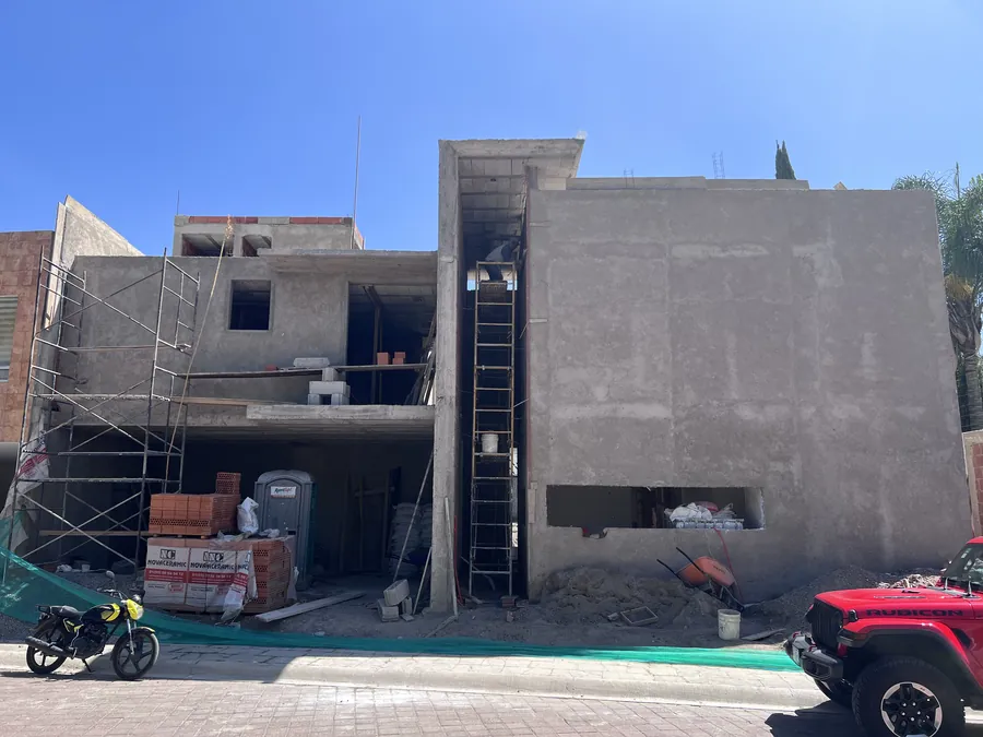 Casa en obra gris con andamios desde la calle — proceso de construcción de casa residencial en Puebla