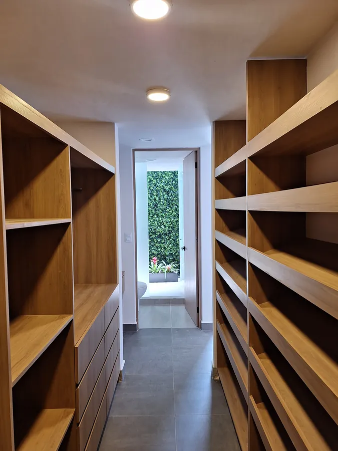 Vestidor con repisas de madera a ambos lados — casa Missouri 99 en el corredor Angelópolis, Puebla