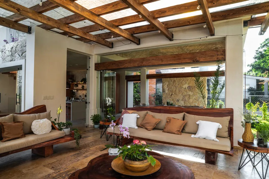 Estancia con vigas de madera abierta al jardín — casa residencial de autor en Atlixco, Puebla