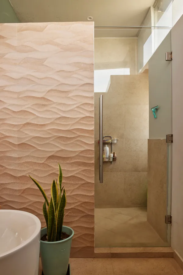 Baño con muro texturizado en relieve — penthouse en Lomas de Angelópolis, Puebla