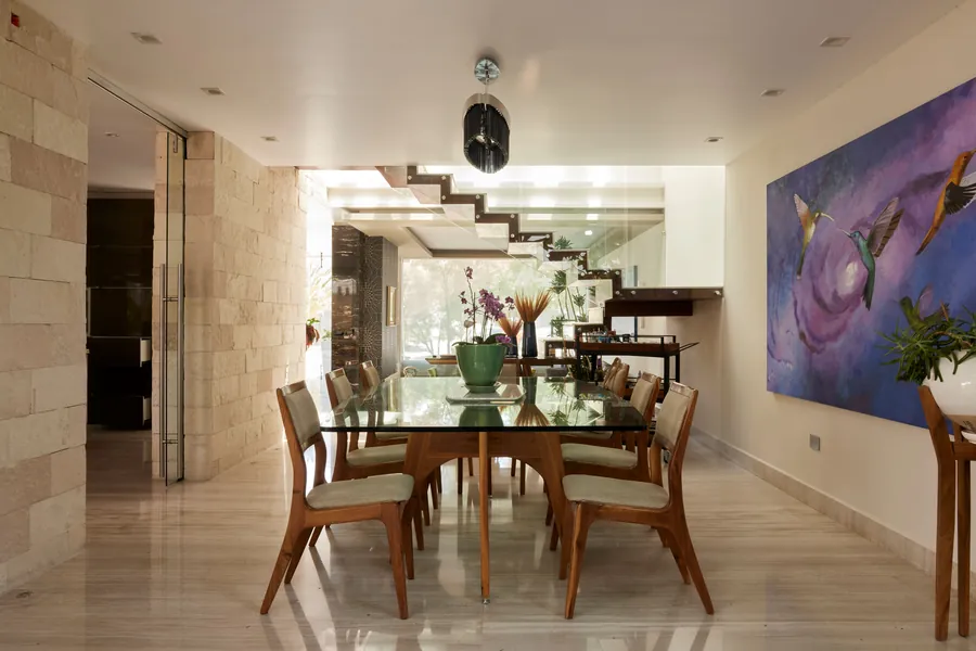 Comedor con escalera flotante y arte — penthouse en Lomas de Angelópolis, Puebla